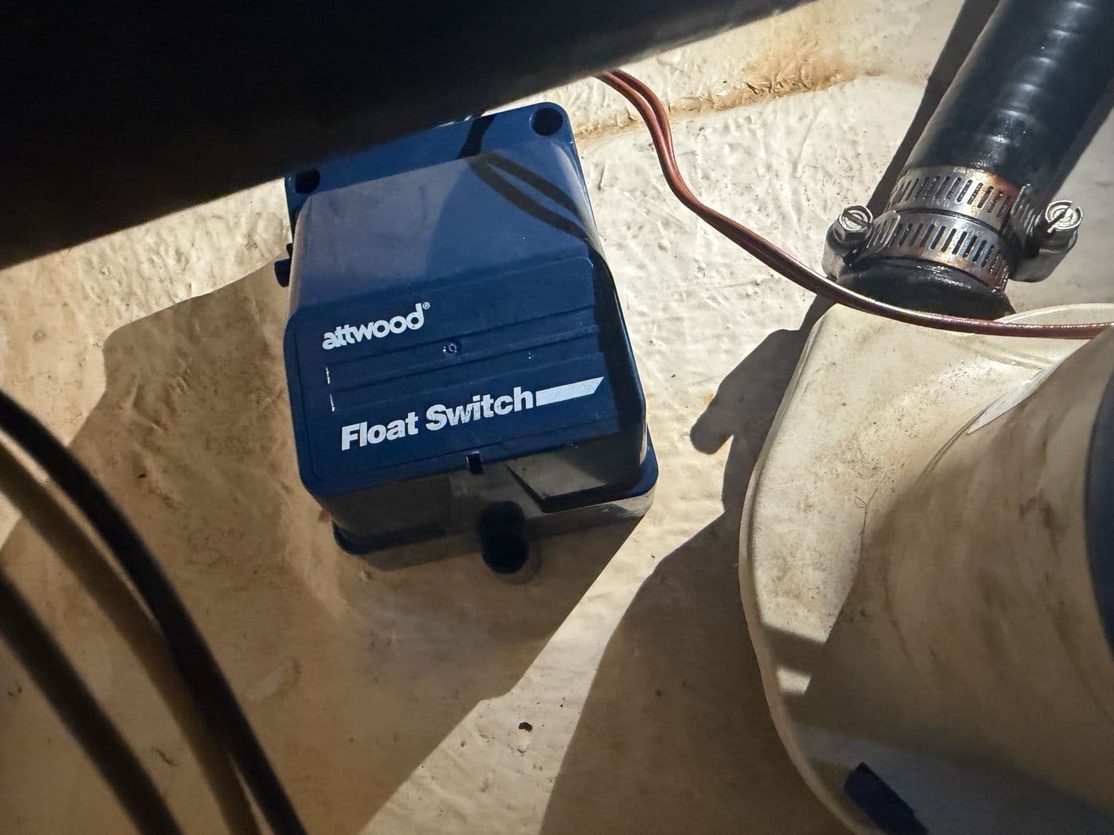 Attwood Automatic Float Switch in a stained bilge, labeled as the failed unit