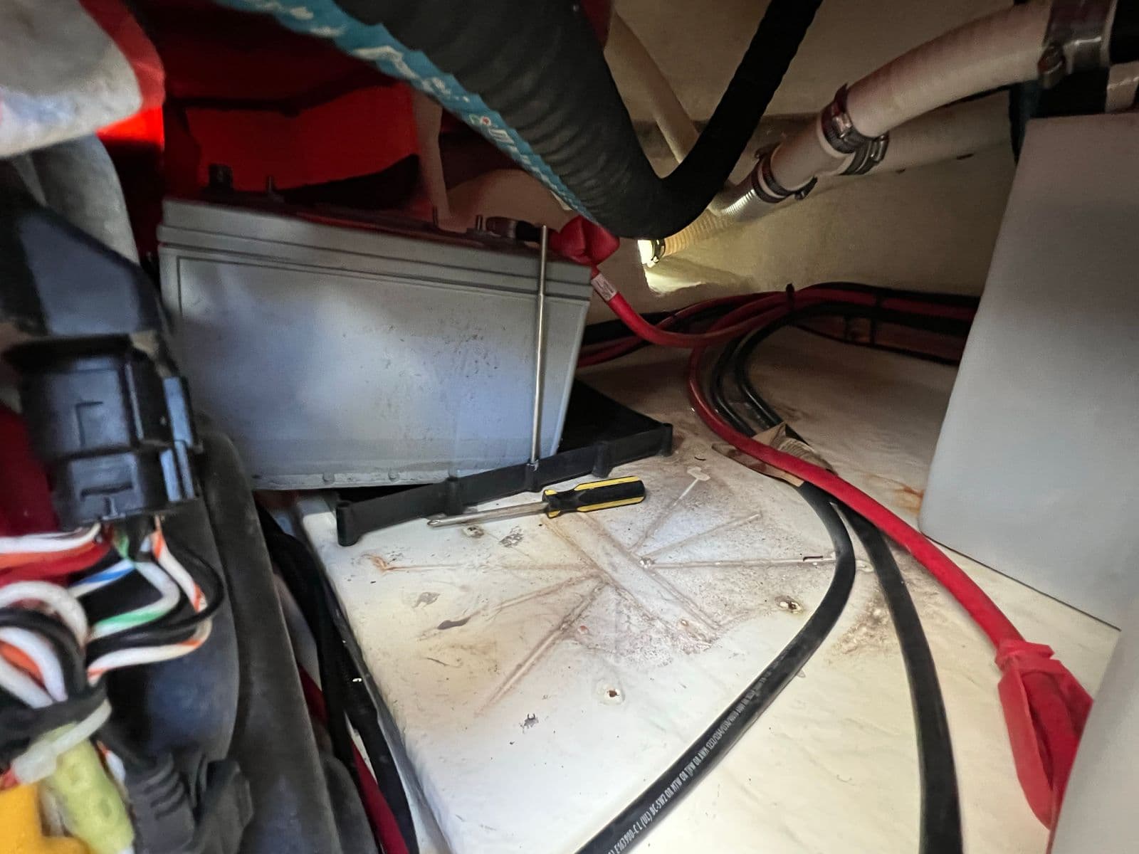 Battery install in progress with the hot water heater repositioned and an exhaust hose pulled aside