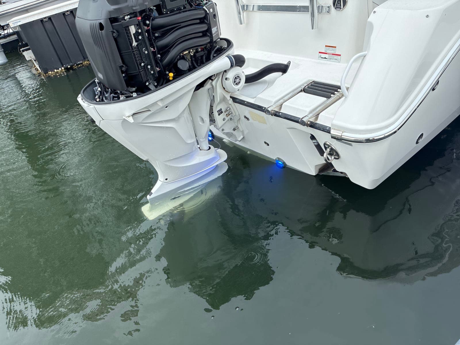 Open outboard cowling on a boat in the water at a Tampa Bay dock during mobile engine service