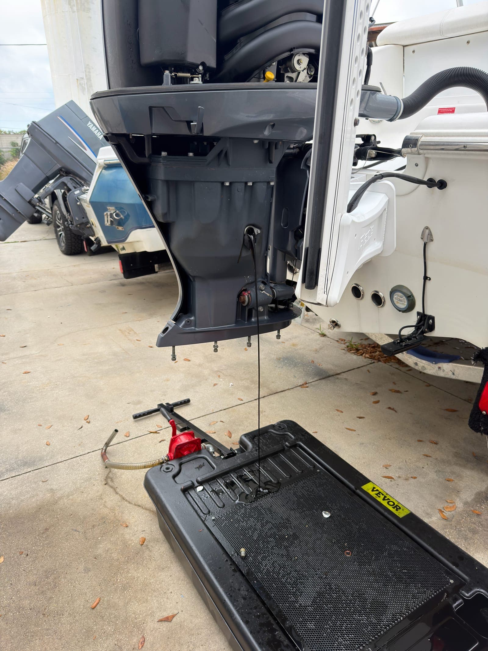 Mobile Marina performing dockside 100-hour outboard service with cowling removed for access