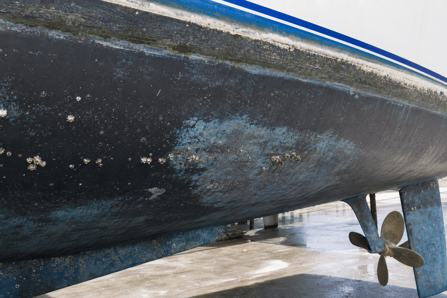 Worn antifouling paint and light marine growth on a boat hull after haul-out